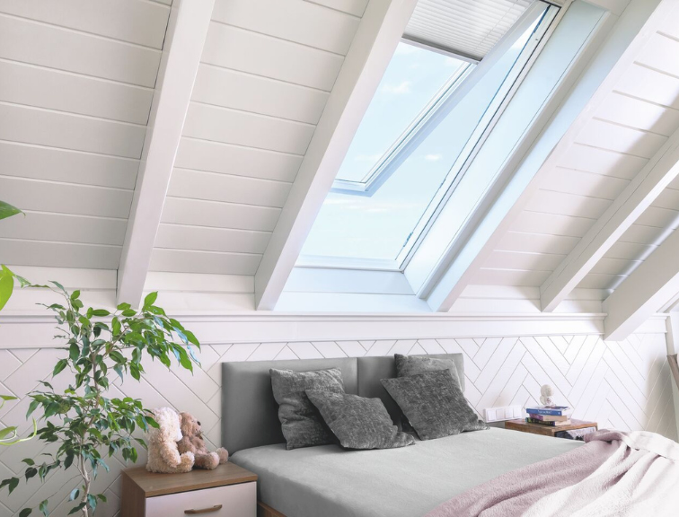 Helles, modern eingerichtetes Schlafzimmer mit einem Roto Designo I8 Dachfenster, das natürlichen Tageslichteinfall ermöglicht