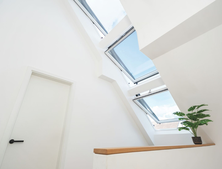Blick von unten in einen Flur mit einem Roto Designo R6 Tronic Dachfenster, das natürlichen Tageslichteinfall ermöglicht