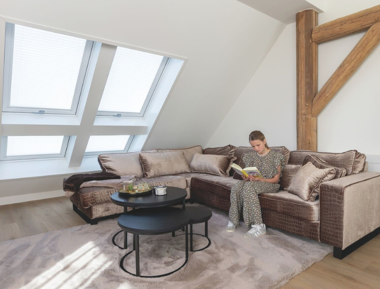 Modernes, helles Wohnzimmer mit einem Roto Designo R8 Dachfenster, das für natürlichen Tageslichteinfall sorgt