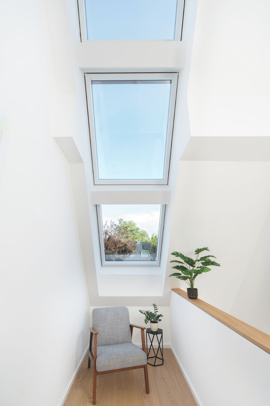 Heller, modern gestalteter Flur mit einem Roto Designo R6 Tronic Dachfenster, das natürlichen Tageslichteinfall ermöglicht