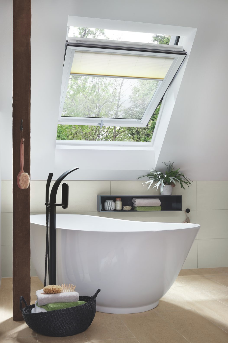 Helles Badezimmer mit Badewanne, beleuchtet durch ein Roto Designo R6 Dachfenster für eine angenehme Lichtstimmung
