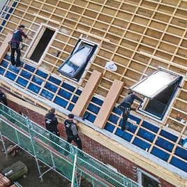 Handwerker tauschen mehrere Dachfenster aus