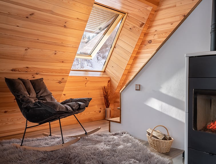 Kaminzimmer unter dem Dach mit geöffnetem Roto Dachfenster.