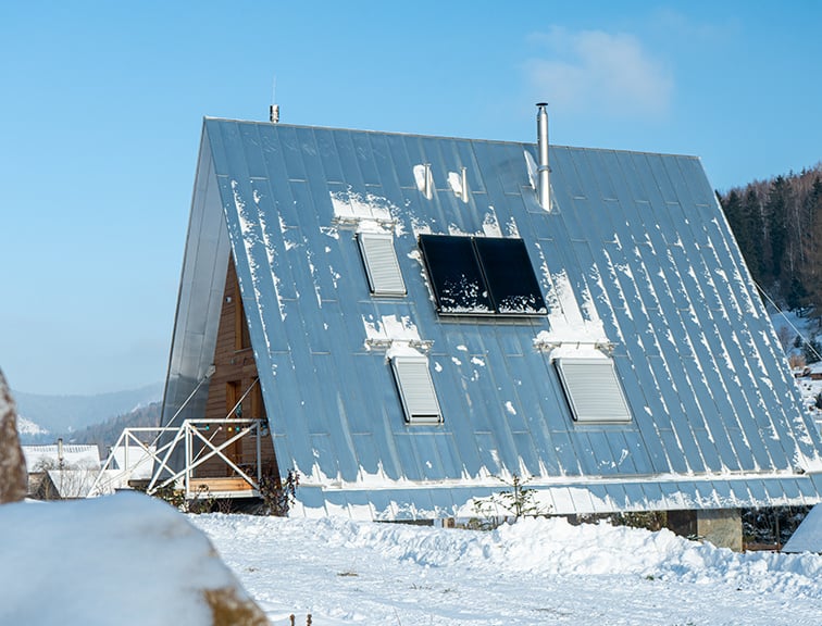 Haus mit geschlossenen Roto Außenrollläden in Schneelandschaft.