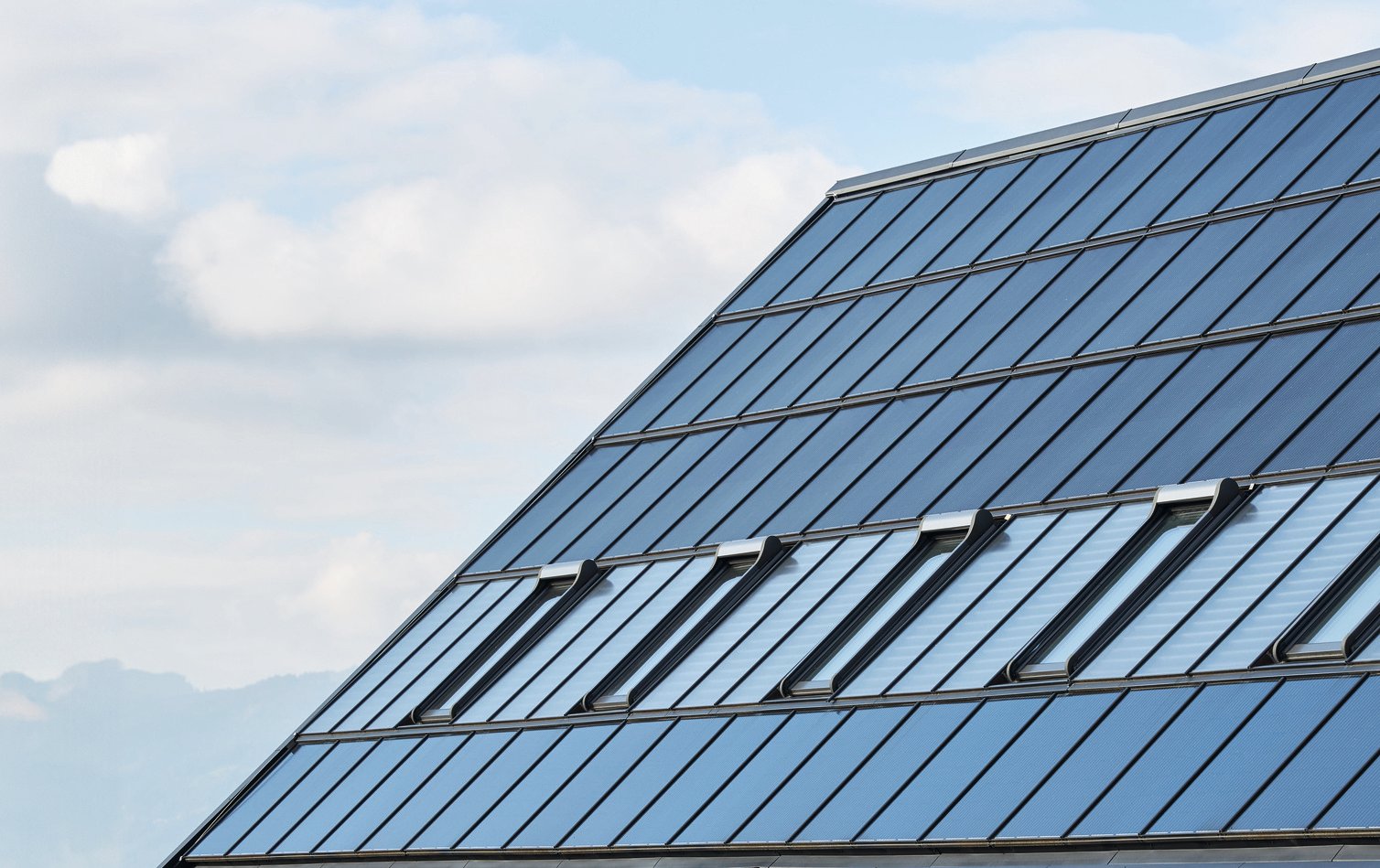Zicht op dak met fotovoltaïsche panelen en dakvenster