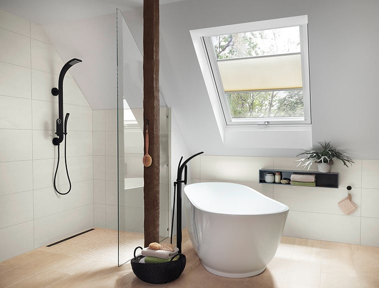 Badezimmer mit Wanne und Dusche unter dem Dach