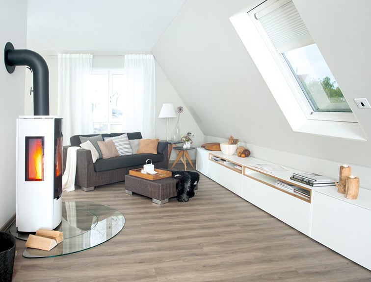 Wohnbereich unter dem Dach mit Kamin, Sofa und Möbel.