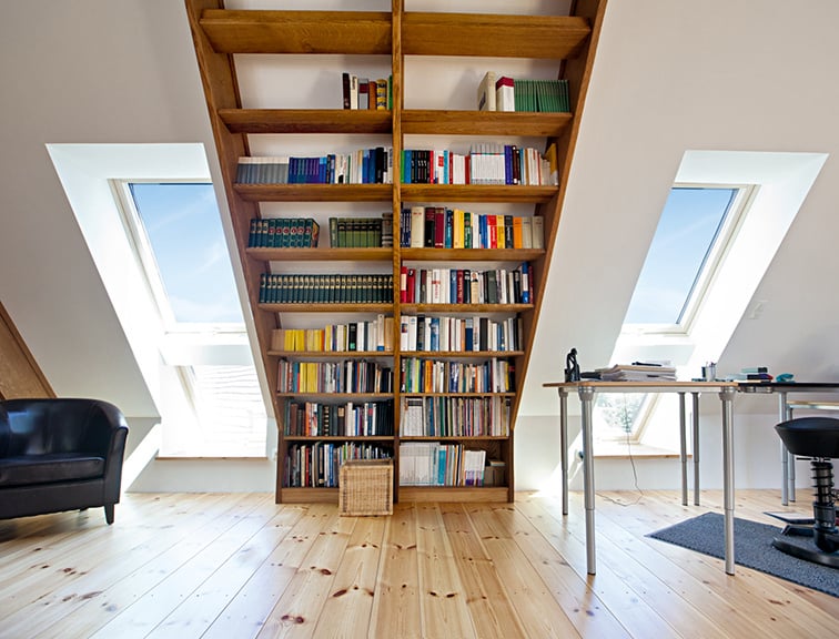 Dachgeschoss mit Bücherregal an der Dachgeschräge.