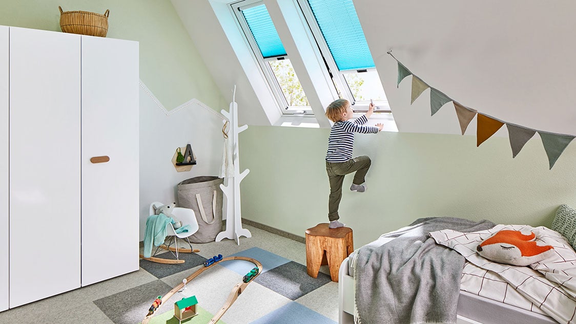 Junge in Kinderzimmer mit Dachfenstern von Roto