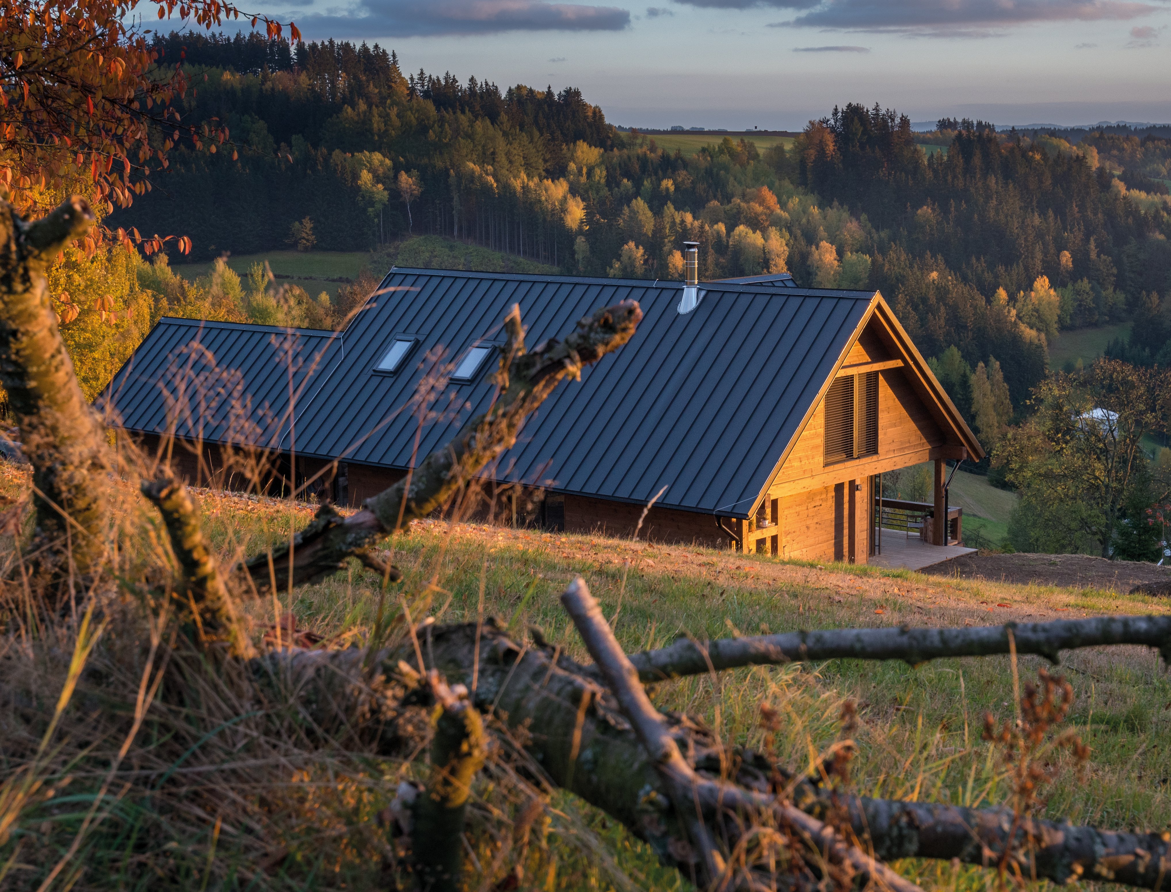 Holzhaus von hinten mit Roto Dachfenstern und Blick in die Berge