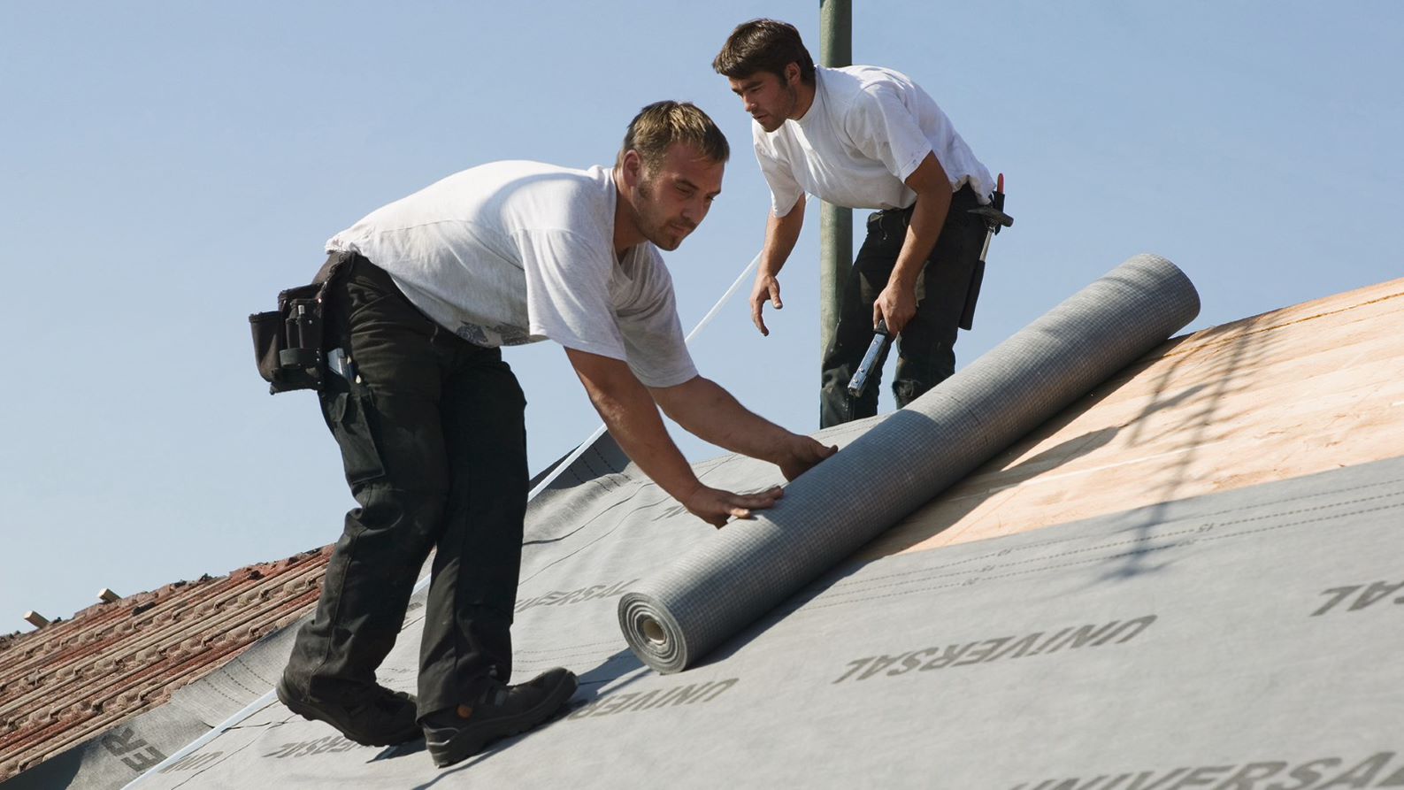 Zwei Handwerker beim Dach eindecken