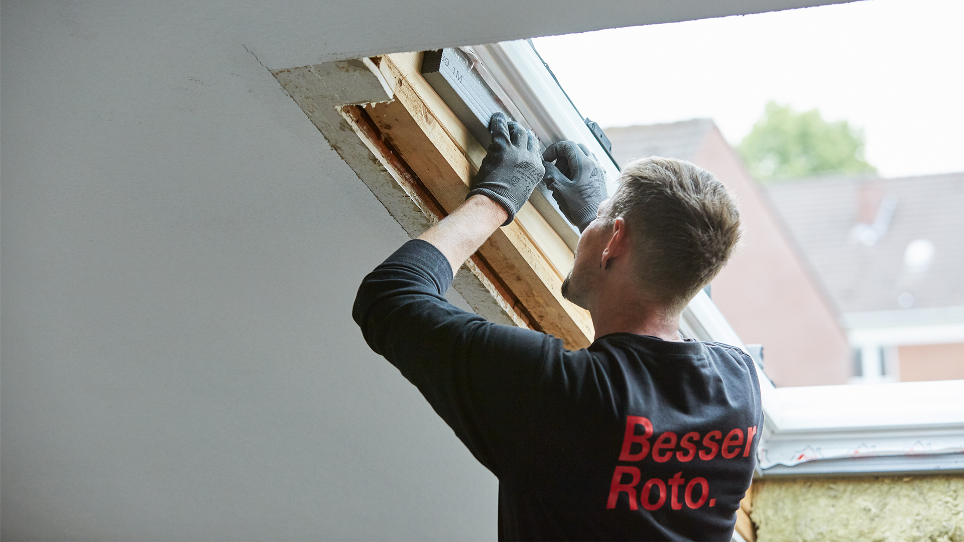 Handwerker nimmt Maße am Fenster